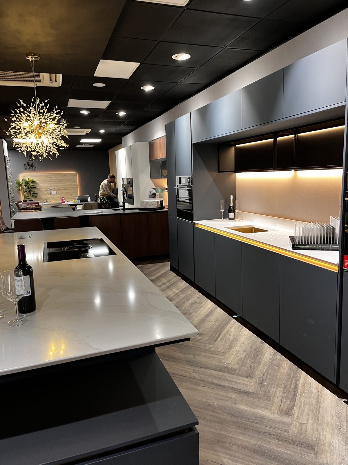 Recessed spotlights, a starburst pendant and under-cabinet LED strips in a kitchen